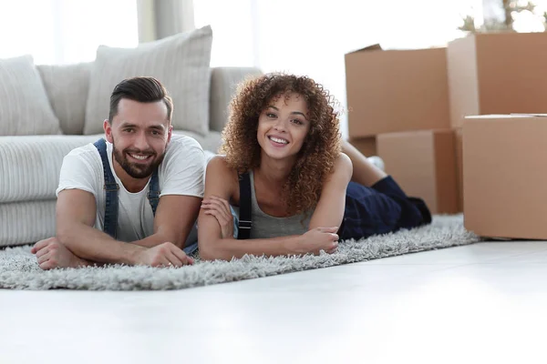 Ευτυχισμένο ζευγάρι έγκειται στο πάτωμα σε ένα νέο διαμέρισμα — Φωτογραφία Αρχείου