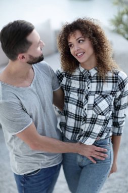 mutlu genç çift birbirlerine sarılıyor.