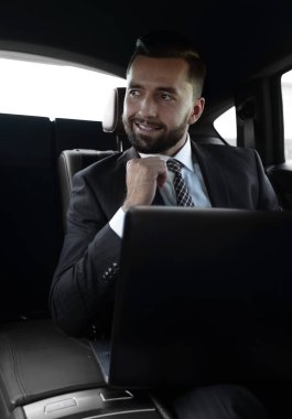 Bir arabanın arka koltuğunda oturan başarılı adam