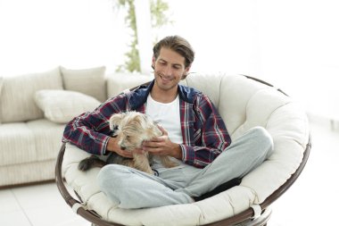 yakışıklı olan büyük bir koltukta oturan bir köpekle.