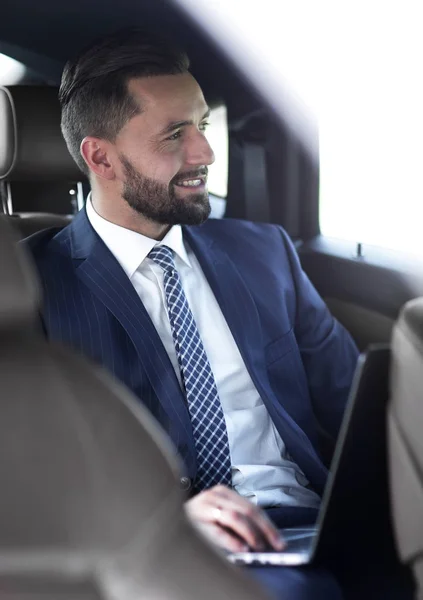 Portrait of a business man in the back seat of a car