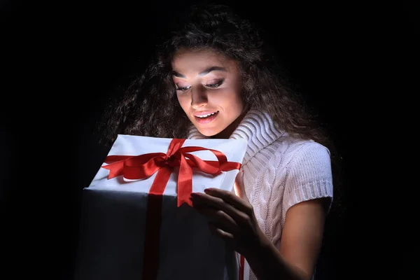 Ritratto di una bella giovane bruna che sbircia in una confezione regalo — Foto Stock