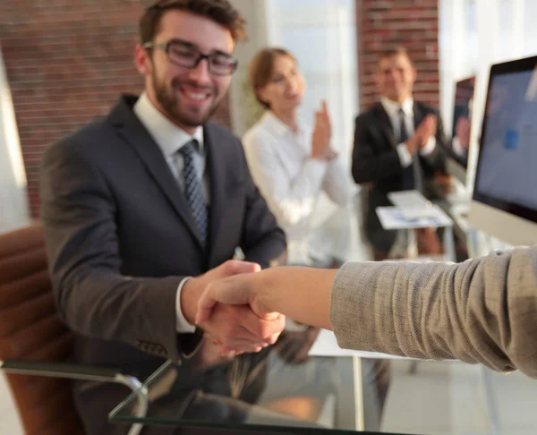 Zakenman die zijn handen schudden met een zakenpartner zitten in de buurt van uw bureaublad — Stockfoto