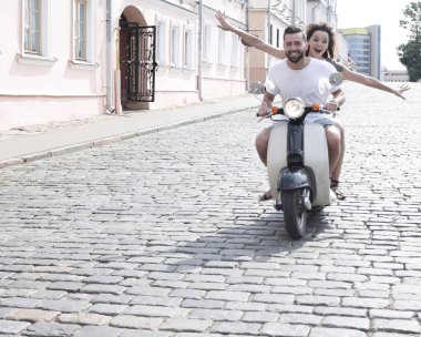 mutlu genç bir çift bir scooter üzerinde eğleniyor