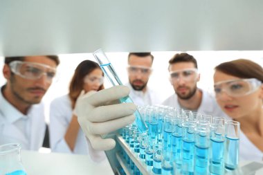 arka plan görüntüsü sıvı cam tüp içinde eğitim microbiologists oluşan bir gruptur.