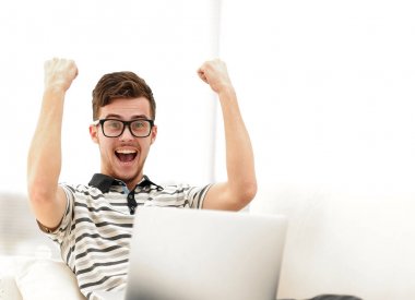 mutlu adam kanepede oturan dizüstü bilgisayar ile