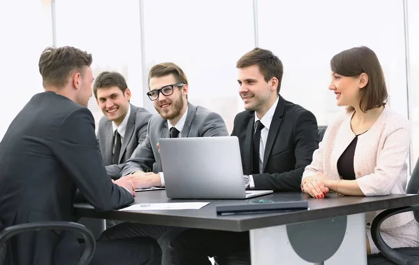 Hombre de negocios hablando con un equipo de negocios en un escritorio — Foto de Stock