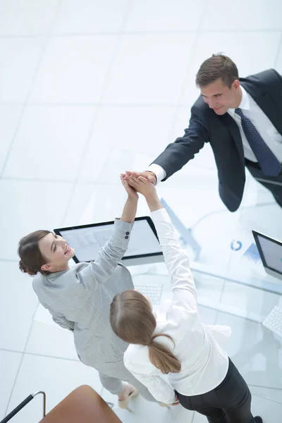 Vista a partir do topo. Membros da equipe de negócios dando uns aos outros um alto cinco acima da mesa . — Fotografia de Stock