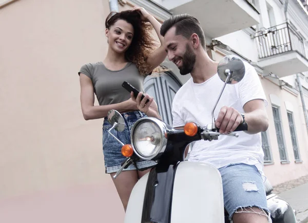 Joven feliz pareja montando scooter juntos sonriendo —  Fotos de Stock