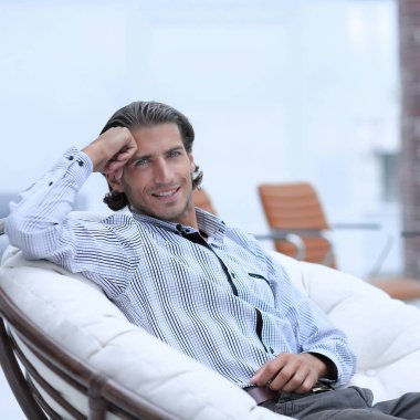 Lobide bir sandalyede oturan işadamı