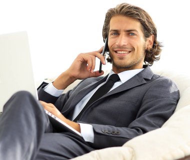 onun evinde sandalyede oturan smartphone cep telefonu ile konuşurken işadamı