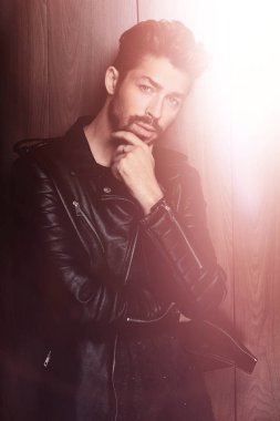 Ahşap duvara yaslanmış yakışıklı bir adamın portresi..