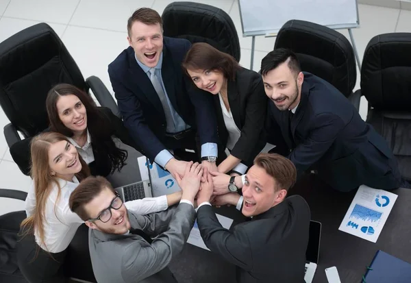 Equipo de negocios con las manos juntas en el escritorio —  Fotos de Stock