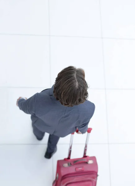 Uomo d'affari con una valigia stradale.isolato su bianco . — Foto Stock