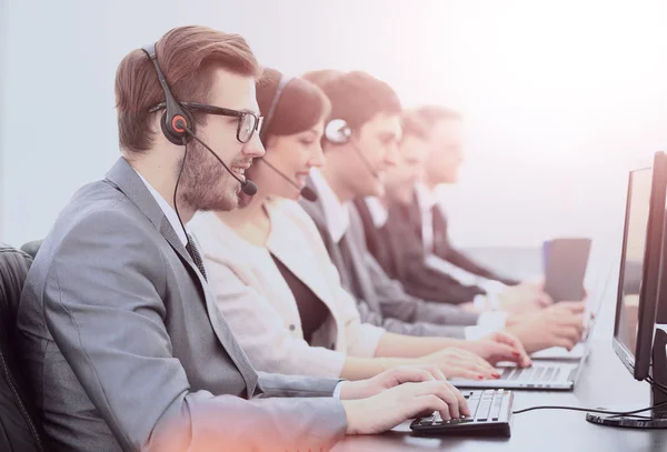 Operadores com fones de ouvido na frente de computadores no call center — Fotografia de Stock