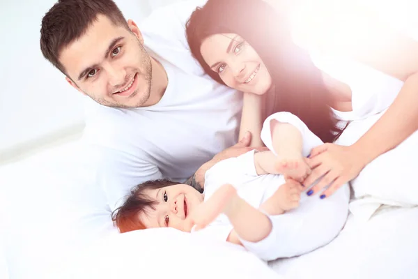 En ung familj med små barn till sängs i sovrummet — Stockfoto
