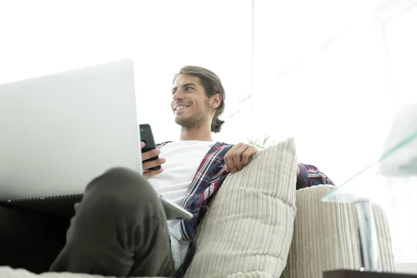 Erfolgreicher Kerl sitzt auf Sofa im Wohnzimmer — Stockfoto