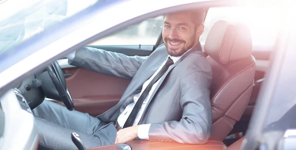 Портрет красивого улыбающегося бизнесмена за рулем своей машины — стоковое фото