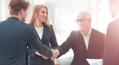 Ortağı ile bir anlaşma imzalamaya tokalaşırken olgun iş adamı