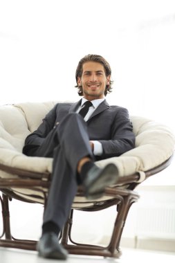 yakışıklı işadamı büyük bir rahat koltukta oturan.