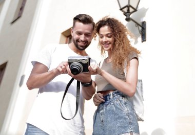 Fotoğraflara bakarak yürüyen genç arkadaşların portresi