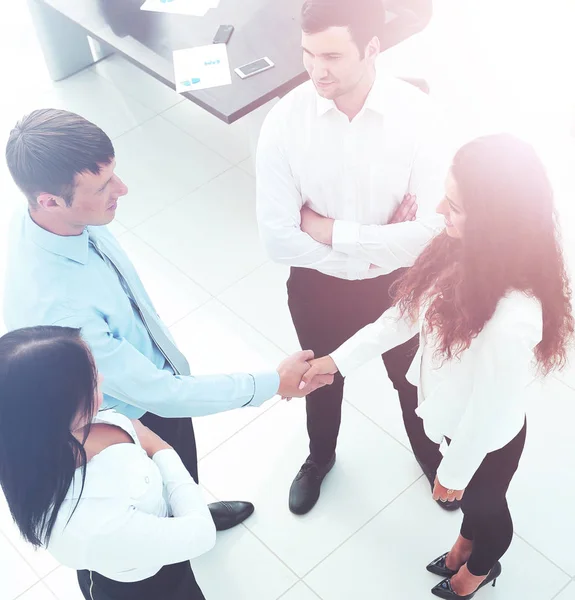 Business partners shaking hands in meeting hall — Stock Photo, Image