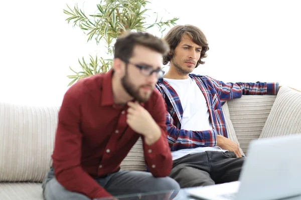 Két webes tervezők megbeszélnek egy projektet egy laptop előtt portréja — Stock Fotó