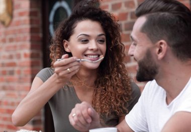 Genç bir çift bir sokak kafede kahve zevk ve gülüyor