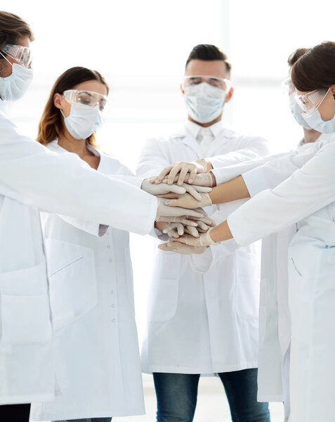 Close-up Photo Of Doctors Stacking Hand With Coworkers