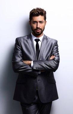 Çapraz kollarla poz veren genç iş adamı.