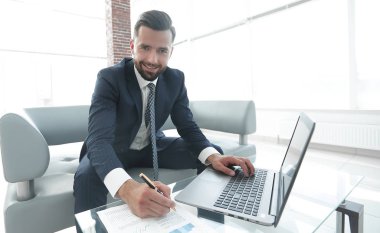 Dizüstü bilgisayarda çalışan ve Notlar not defterinde yapma şık adam