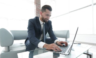 Modern ofis dizüstü bilgisayarda çalışan başarılı erkeğin