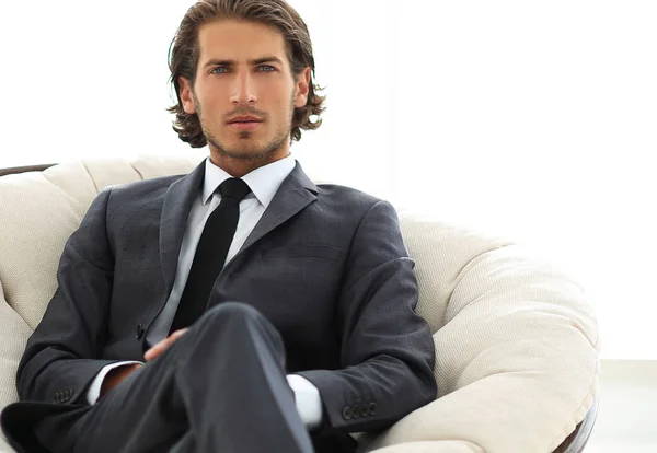 Confident businessman sitting in a large comfortable chair. — Stock Photo, Image