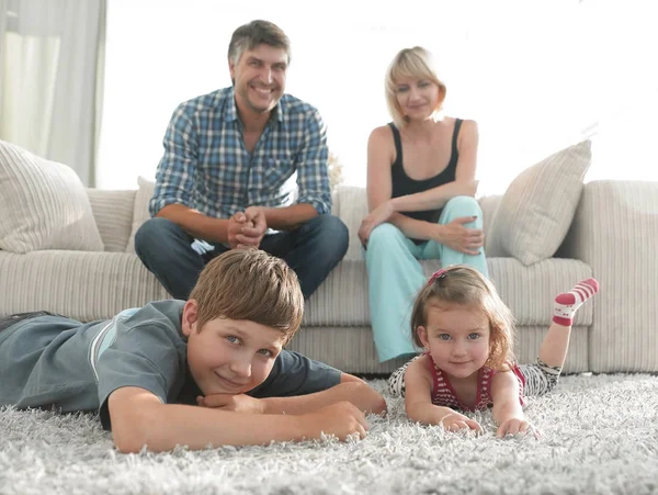 Retrato de família feliz sentados juntos na sala de estar — Fotografia de Stock
