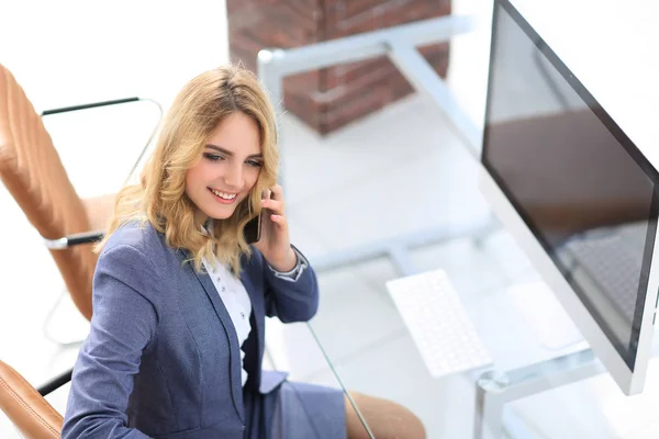 Exitosa joven mujer de negocios sentada en un escritorio — Foto de Stock