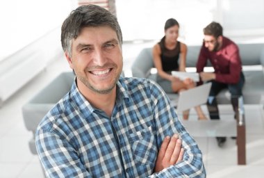 Gülümseyen olgun işadamı ekose gömlek ön planda