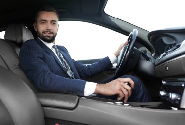 Yan emin işadamı görünümünden bir araba direksiyon başında oturur
