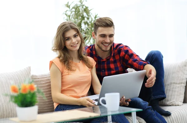Genç çift çalisarak koltukta oturan laptop