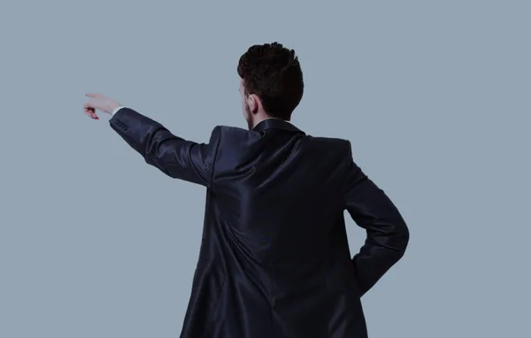 Jovem homem de negócios em um terno apontando com o dedo — Fotografia de Stock