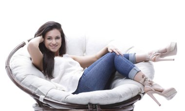 Yuvarlak, yumuşak bir sandalyede dinlenen modern genç kadın..
