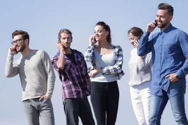 onların akıllı telefonlar üzerinde konuşurken öğrenci grubu.