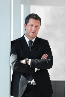 office penceresinde yakınındaki ayakta ciddi iş adamı.