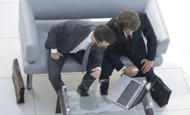 dizüstü bilgisayarda veri tartışırken iş arkadaşları.