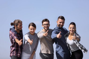 başparmak gösterilmesini gençlerin grup gülümseyen.