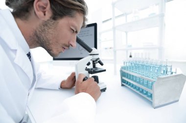 Laboratuar mikroskobu bakarak genç laboratuvar bilim adamı