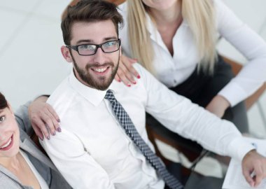 masada oturan ve kameraya bakarak başarılı iş takım.