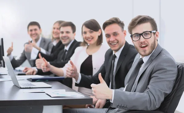 Equipo de negocios con los pulgares hacia arriba mientras está sentado en su escritorio — Foto de Stock