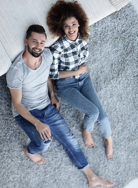 above newlyweds lying on the carpet in a new apartment