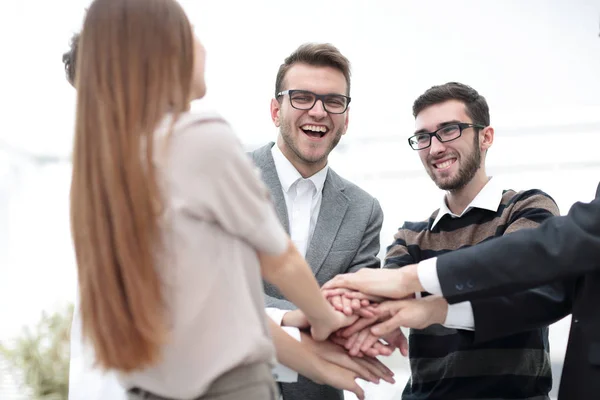 Equipe de negócios de pé unindo as mãos — Fotografia de Stock