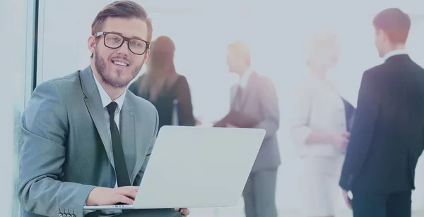 Retrato de un joven hombre de negocios guapo con gente de fondo en la reunión de la oficina — Foto de Stock